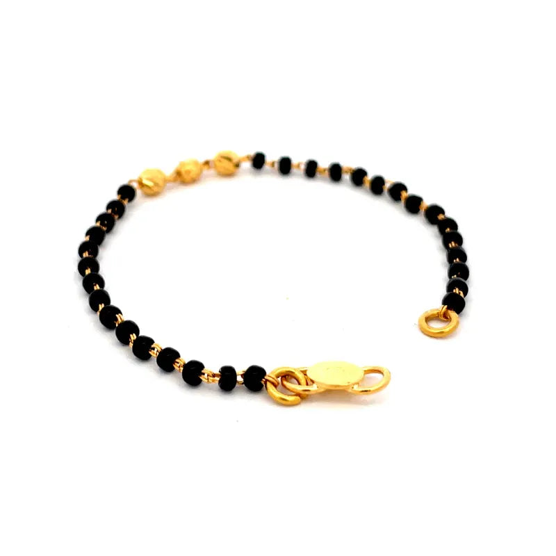 Elegant 22K yellow gold baby bracelet with classic black beads for little ones