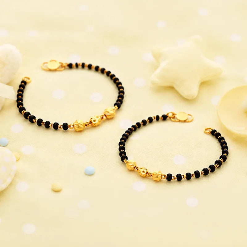 Elegant 22K yellow gold baby bracelet with classic black beads for little ones